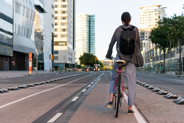 Foto joven irreconocible en la ciudad en bicicleta