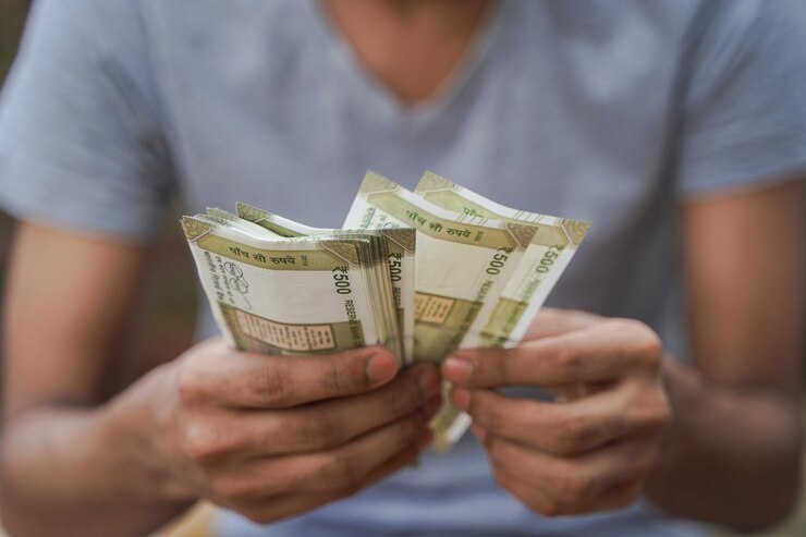 Joven irreconocible contando quinientas rupias indias Cerca de la mano contando efectivo