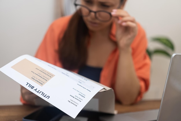 Una joven irritada mira la factura de servicios públicos preocupada por problemas con el pago de la hipoteca al banco