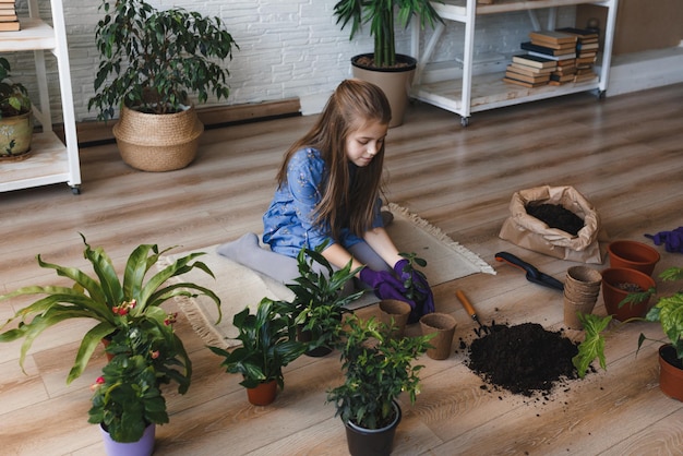 Una joven jardinera cuida las plantas y las flores del hogar.