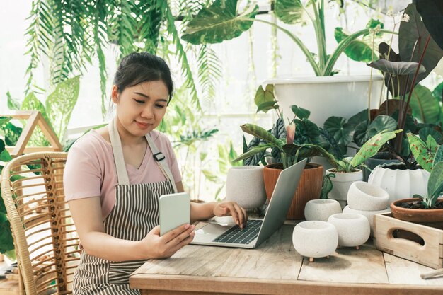 La joven jardinera está parada en el jardín para contactar a los clientes