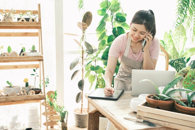 La joven jardinera está parada en el jardín para contactar a los clientes