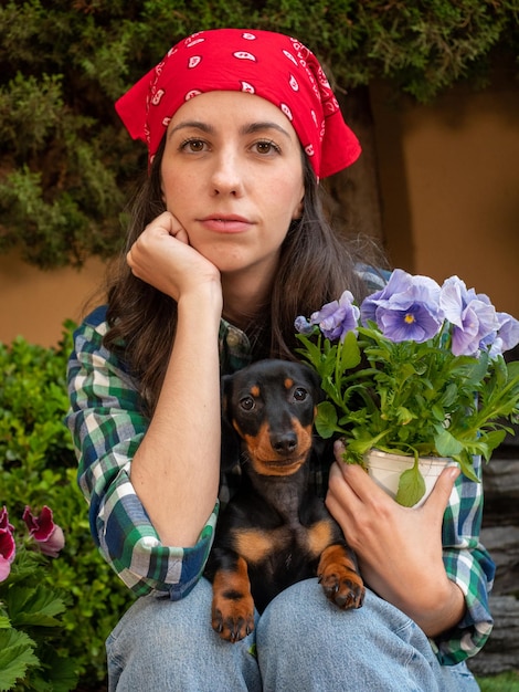 Joven Jardinería en casa con su perrito teckel