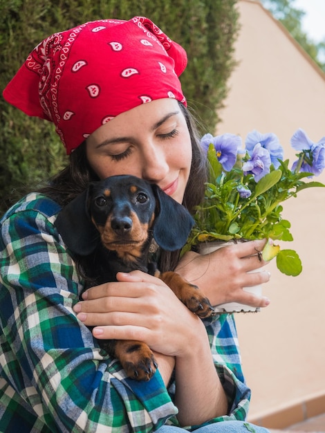 Foto joven jardinería en casa con su perrito teckel