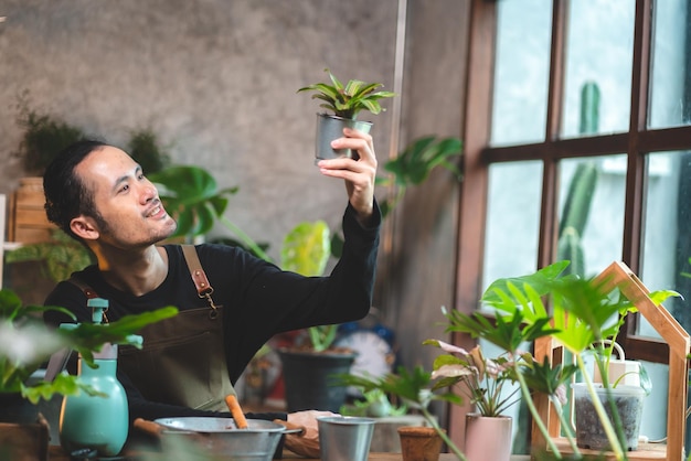 Joven jardinería una planta en hobby en casa naturaleza florista persona estilo de vida en concepto verde