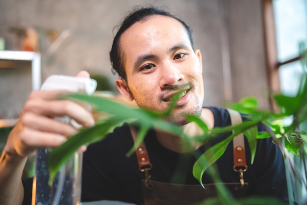 Joven jardinería una planta en hobby en casa naturaleza florista persona estilo de vida en concepto verde