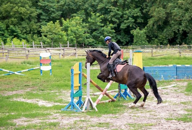 Joven jinete en salto de obstáculos