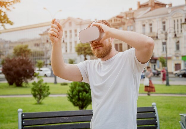 Un joven juega un juego con gafas de realidad virtual en la calle.