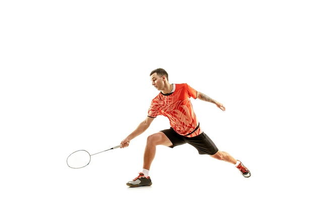 Joven jugador de bádminton masculino sobre fondo blanco.