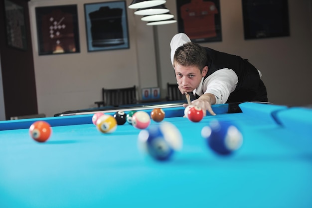 joven jugador de billar profesional que encuentra la mejor solución y el ángulo correcto en el juego deportivo billard o snooker pool