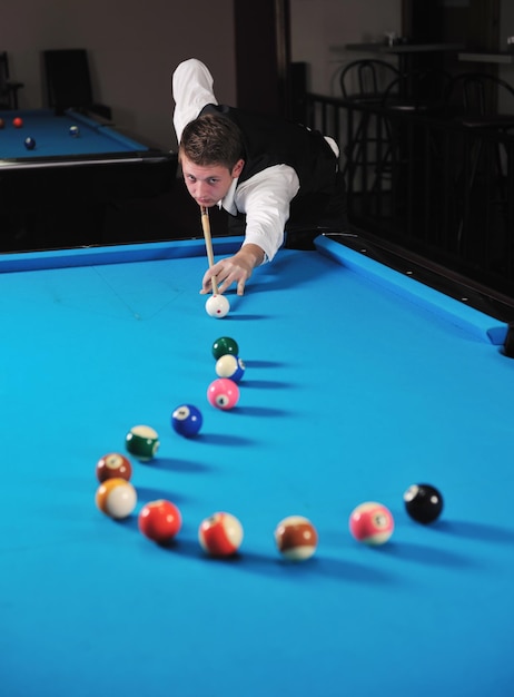 joven jugador de billar profesional que encuentra la mejor solución y el ángulo correcto en el juego deportivo billard o snooker pool