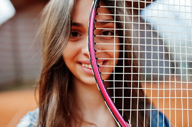 Joven jugador deportivo con raqueta de tenis en la cancha de tenis.