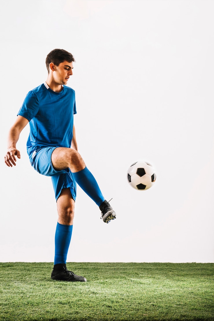 Foto joven jugador de fútbol haciendo malabares con la pelota