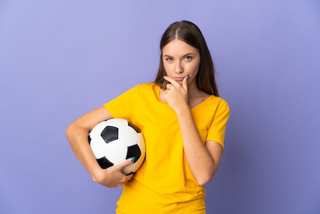 Joven jugador de fútbol lituano mujer aislada en el pensamiento de pared púrpura