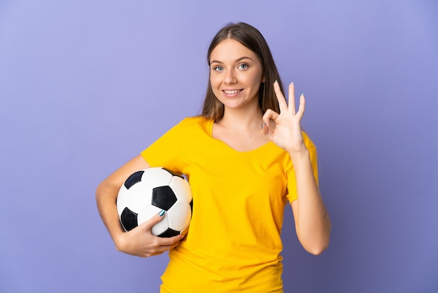 Joven jugador de fútbol lituano mujer aislada sobre fondo púrpura mostrando el signo de ok con los dedos