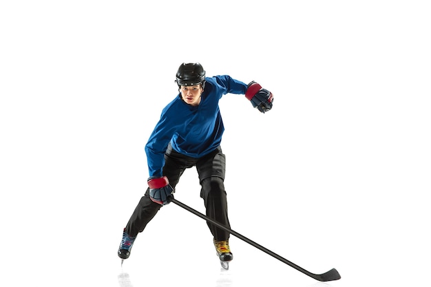 Joven jugador de hockey con el palo en la pista de hielo y fondo blanco.