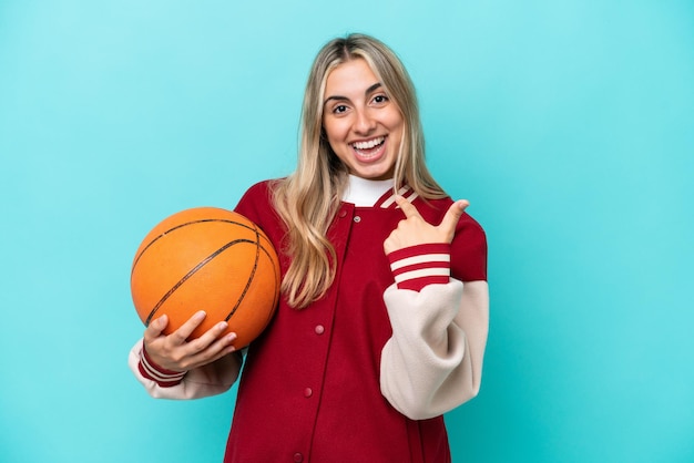 Joven jugadora de baloncesto caucásica mujer aislada de fondo azul con expresión facial sorpresa