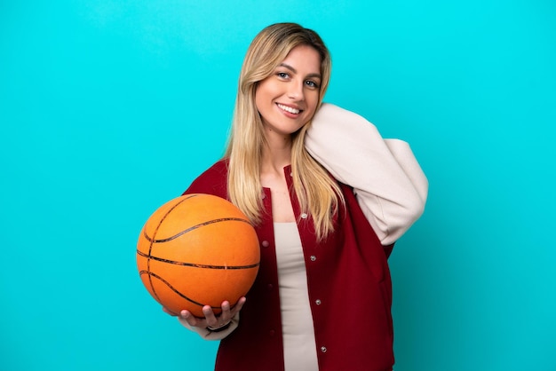 Joven jugadora de baloncesto caucásica mujer aislada de fondo azul riendo