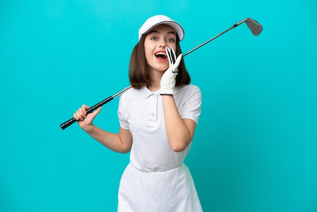 Joven jugadora de golf ucraniana aislada de fondo azul con expresión facial sorprendida y sorprendida
