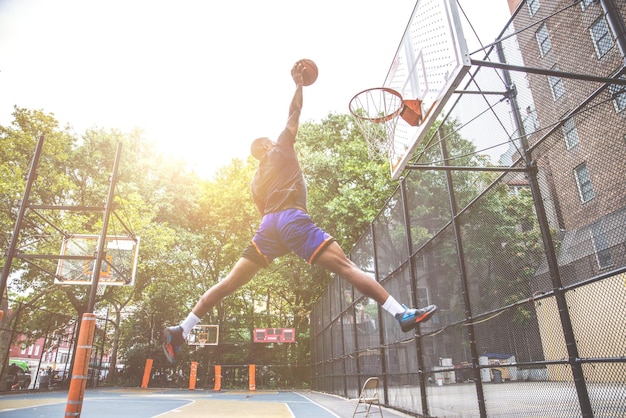 Un joven jugando al baloncesto en la cancha.