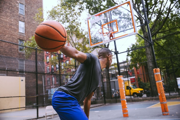 Foto joven jugando al baloncesto en la corte