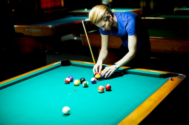 Joven jugando al billar en el bar