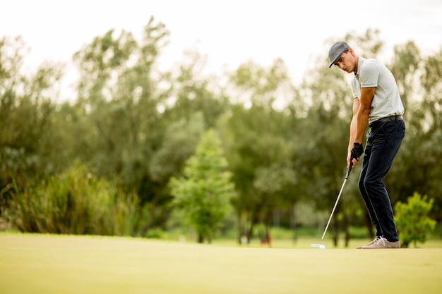 Joven jugando al golf en el campo de golf