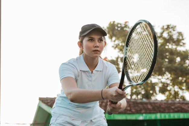 Foto un joven jugando al tenis.