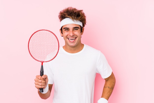 Joven jugando bádminton riendo y divirtiéndose.