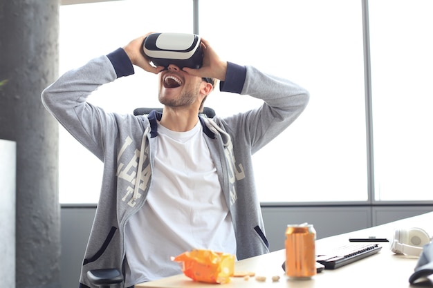 Joven jugando con casco de realidad virtual en el club de juego.