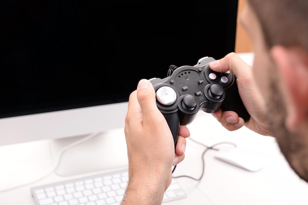 Un joven jugando a los juegos de computadora en casa.