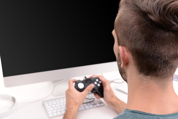 Foto joven jugando a juegos de computadora en casa