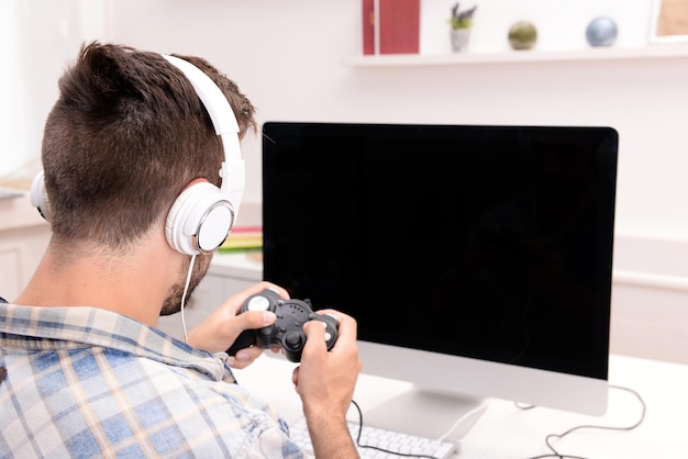 Un joven jugando a los juegos de computadora en casa.