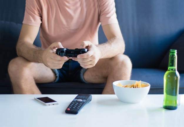 Foto joven jugando videojuegos en casa.