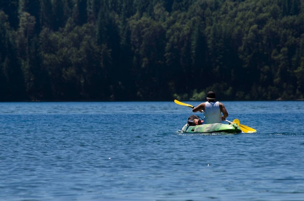 joven en kayak remando en un lago