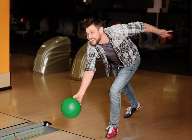 Foto joven lanzando pelota en el club de bolos