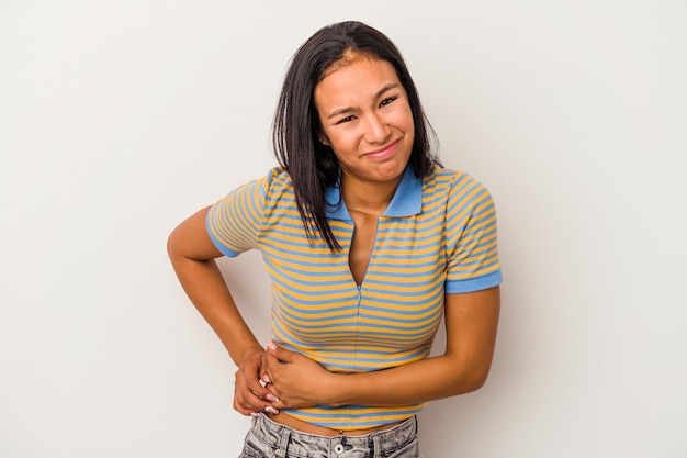 Joven latina aislada de fondo blanco con dolor de estómago y dolor de hígado