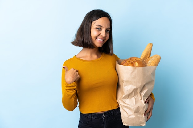 Joven latina comprando algunos panes aislados