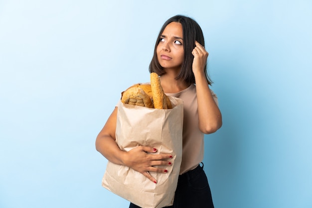 Joven latina comprando algunos panes