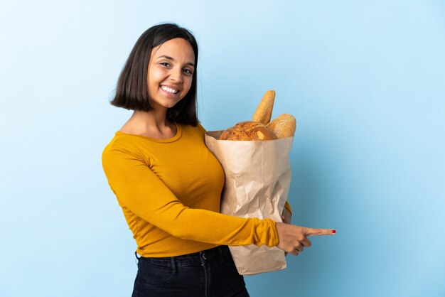 Joven latina comprando algunos panes