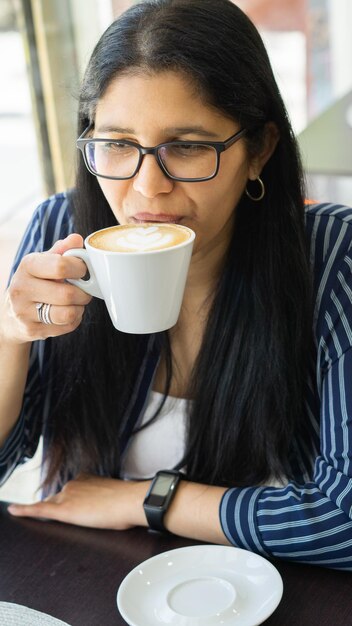 Foto joven latina disfrutando de un delicioso café con arte tardío