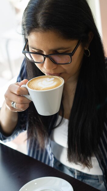 joven latina disfrutando de una taza de café