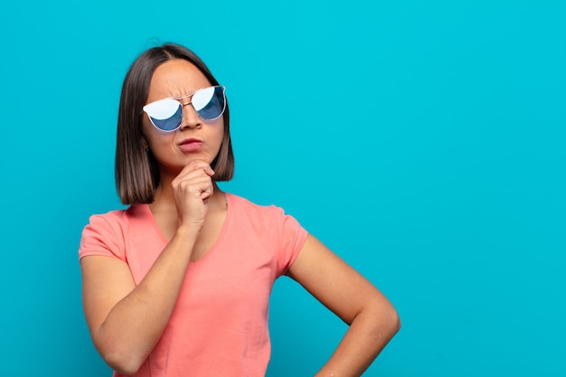 Joven latina con gafas de sol y un espacio de copia