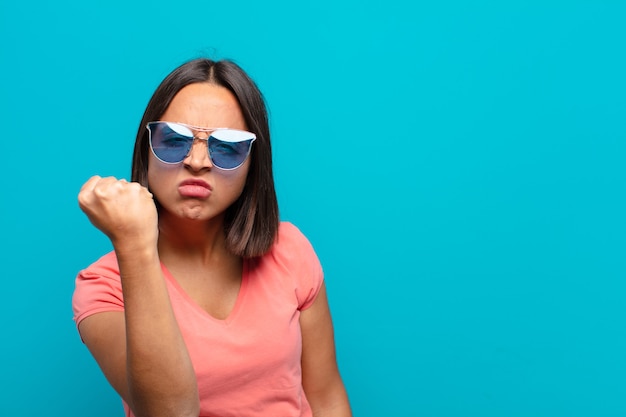 Joven latina con gafas de sol y un espacio de copia