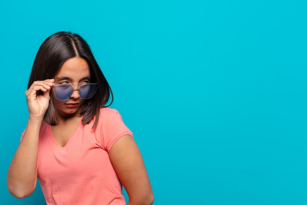 Joven latina con gafas de sol y un espacio de copia