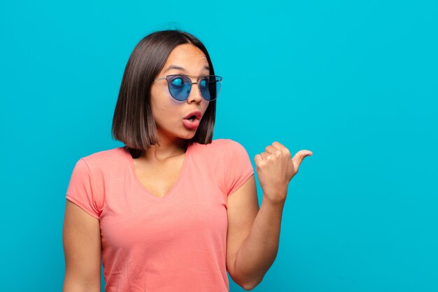 Joven latina con gafas de sol y un espacio de copia