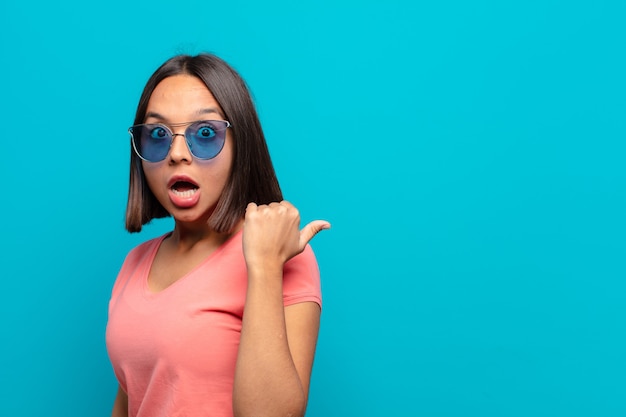 Joven latina con gafas de sol y un espacio de copia