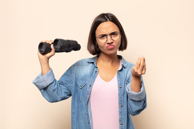 Foto joven latina haciendo capice o gesto de dinero, ¡diciéndole que pague sus deudas!