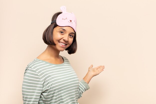 Joven latina que se siente feliz y alegre, sonriendo y dándote la bienvenida, invitándote con un gesto amistoso