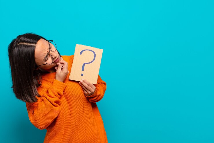 Foto joven latina sosteniendo un letrero de signo de interrogación